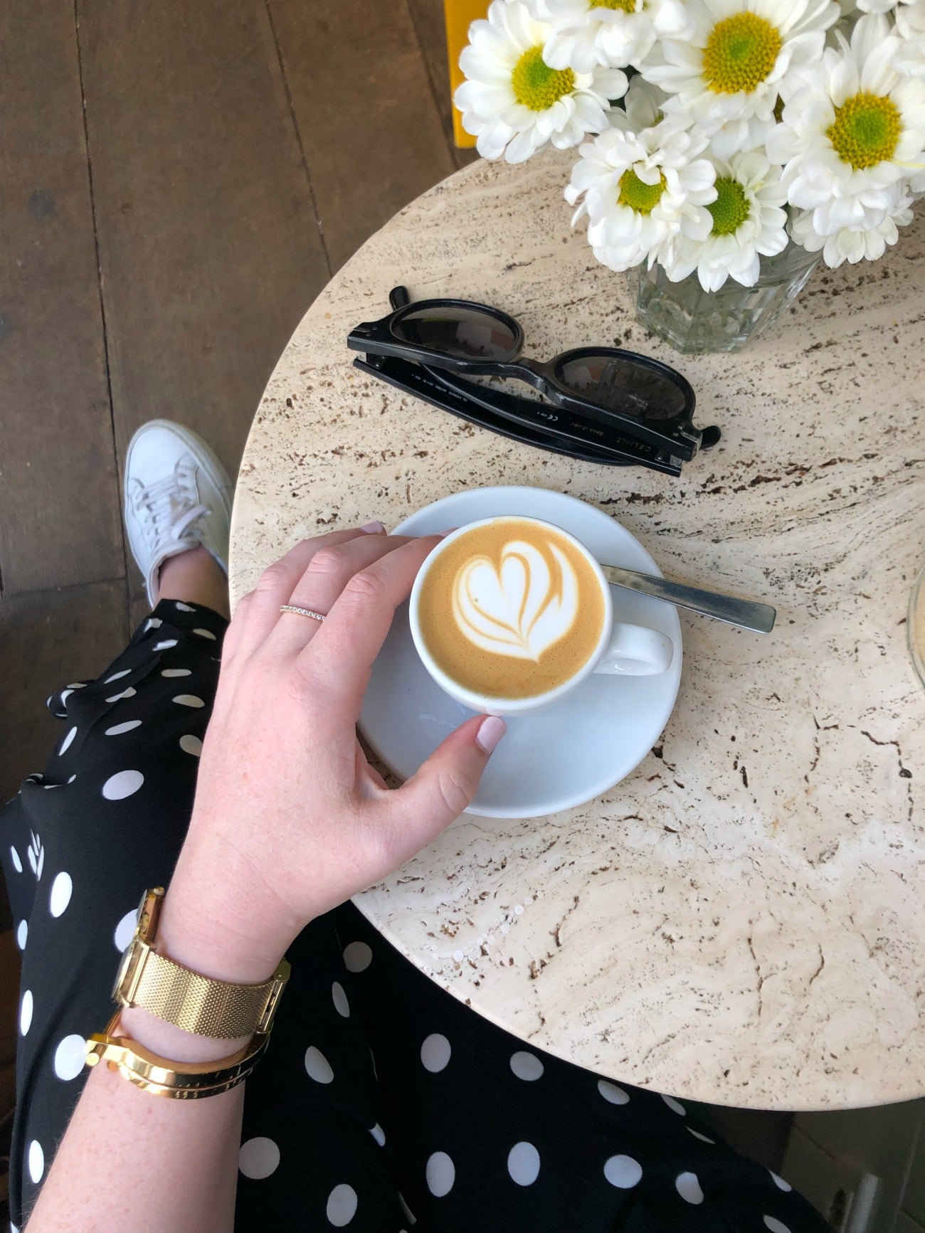 Best Coffee Shops in Paris wit & whimsy holding a cup of latte in Paris