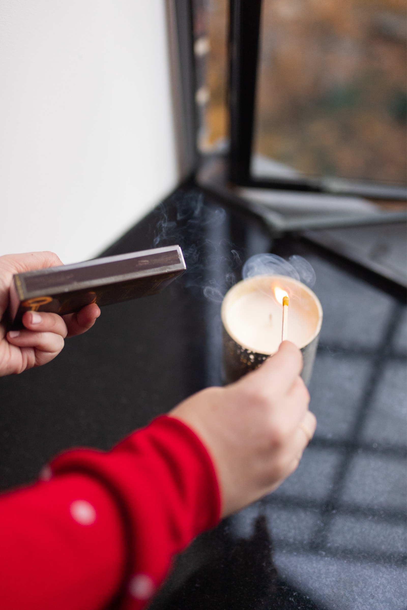 Wit & Whinsy using a match to light a candle.