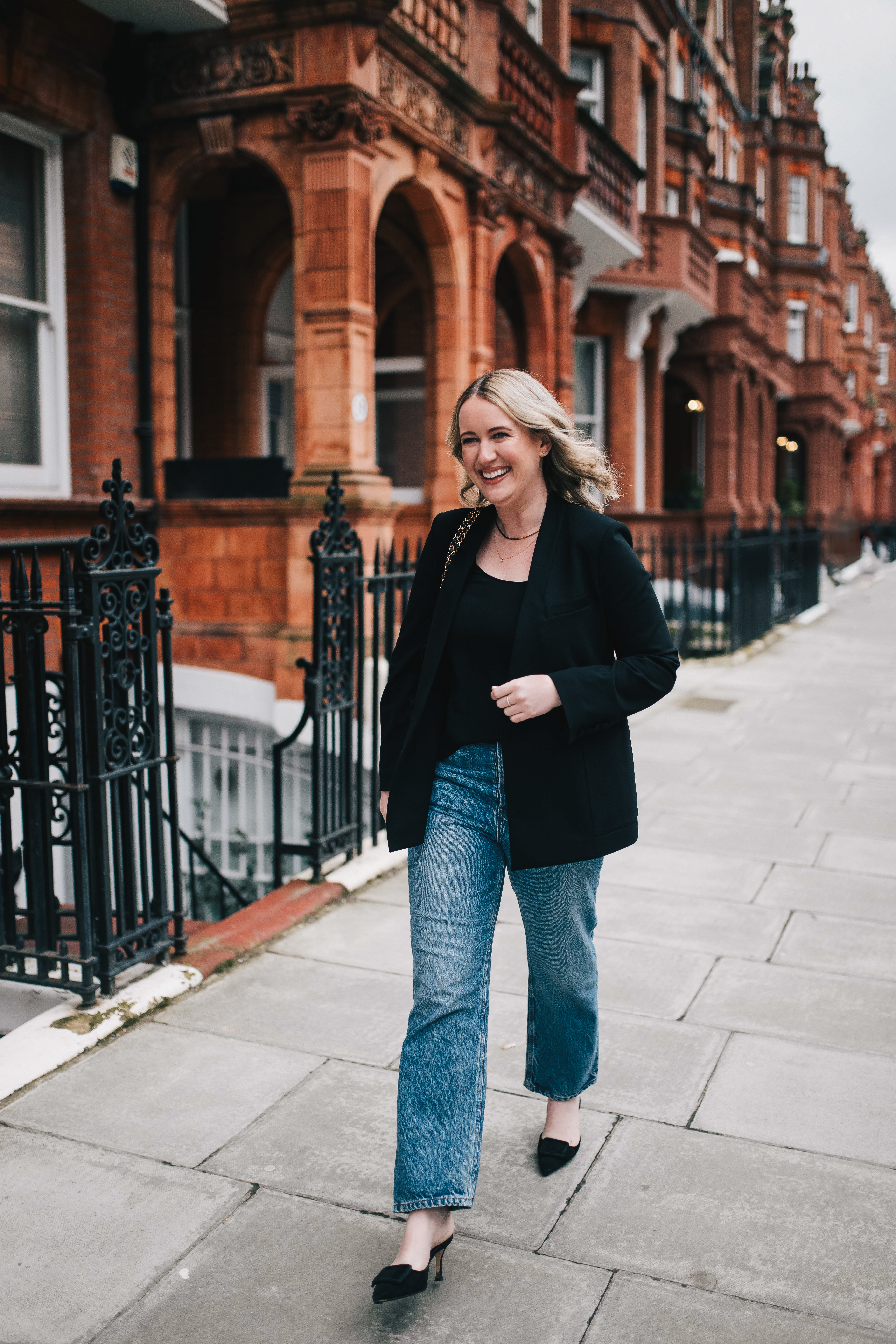 Wit Whimsy Blogger Meghan Donovan shares Things in My Closet I'll Be Wearing this Spring - in photo: Meghan wearing black top, jeans, and black vest