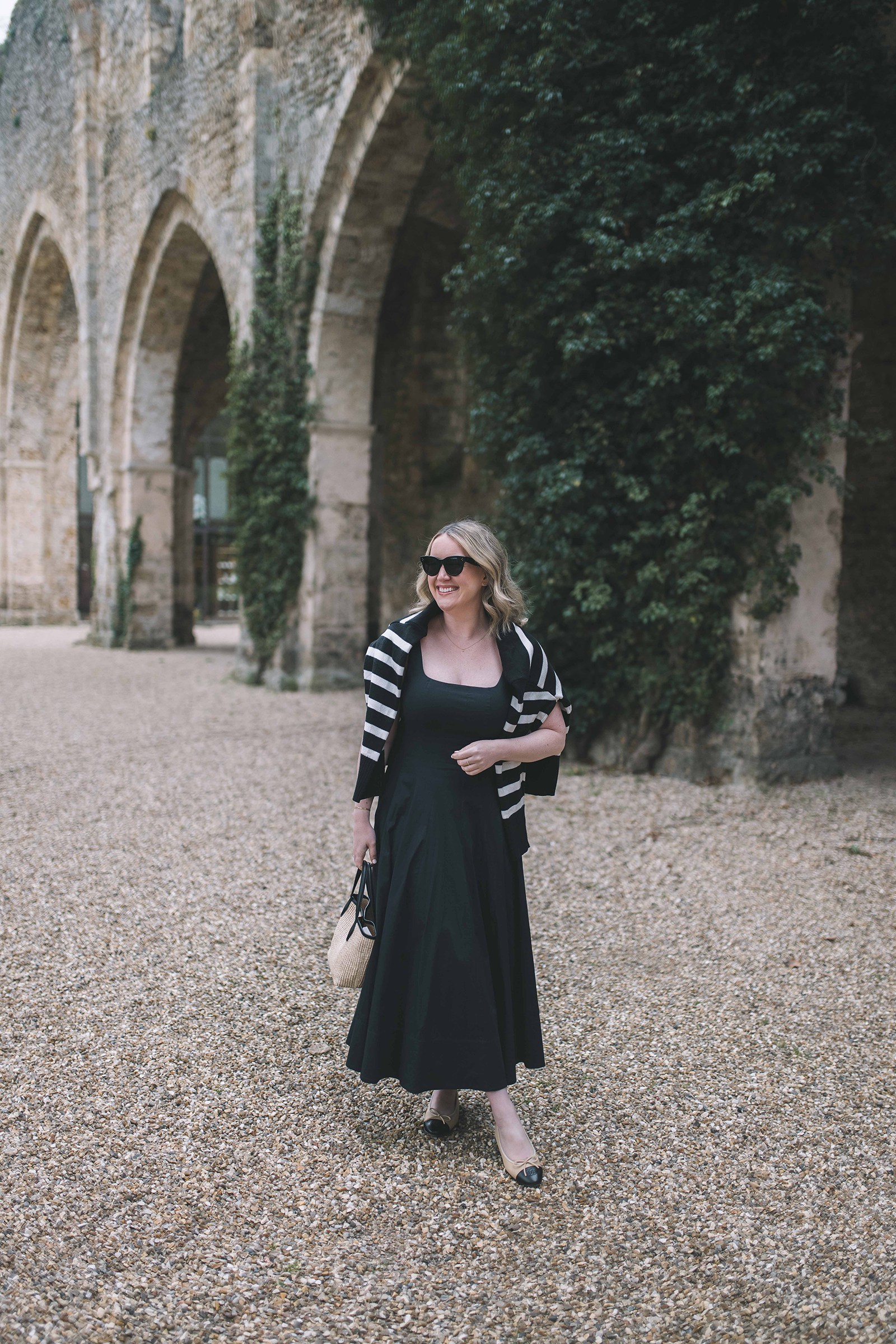  Wit Whimsy Blogger Meghan Donovan shares What to Wear in Paris in the Spring - in photo: Meghan wearing STUAD Wells dress with striped sweater over her shoulders