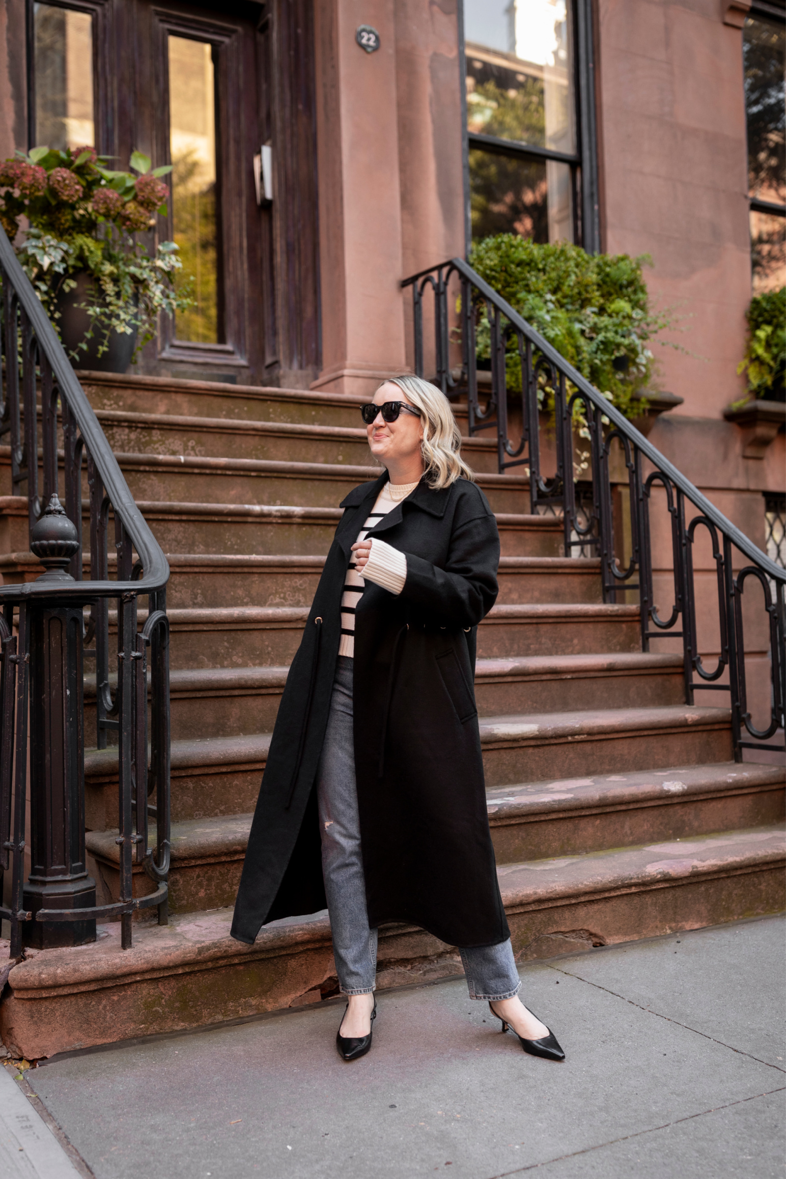 Winter Outfit Ideas Wit Whimsy Blogger Meghan Donovan shares Winter Outfit Ideas - woman wearing a long coat, striped shirt, and denim pants