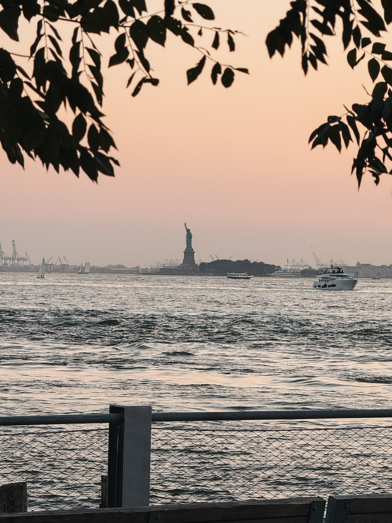 East River during sunset with a view of the Statue of Liberty