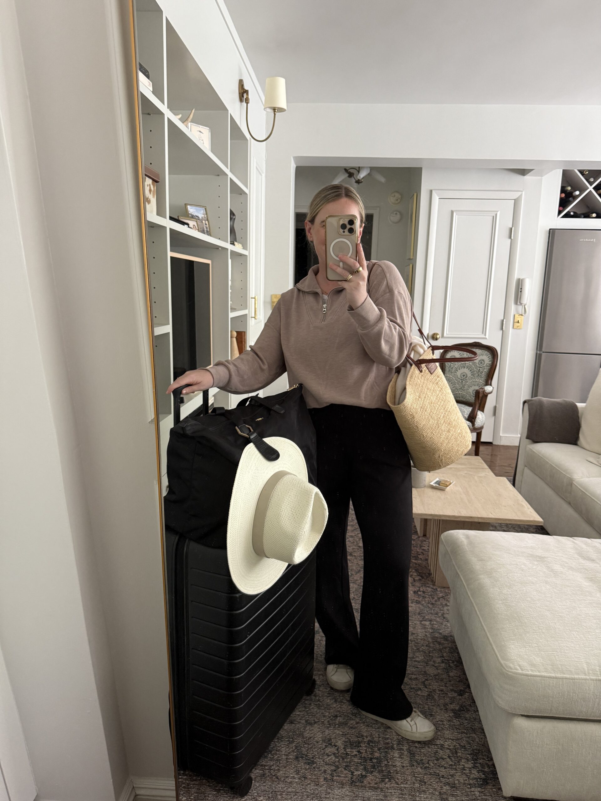 Easy Travel Outfits wit & whimsy wearing a half zip pullover, black trousers and tote