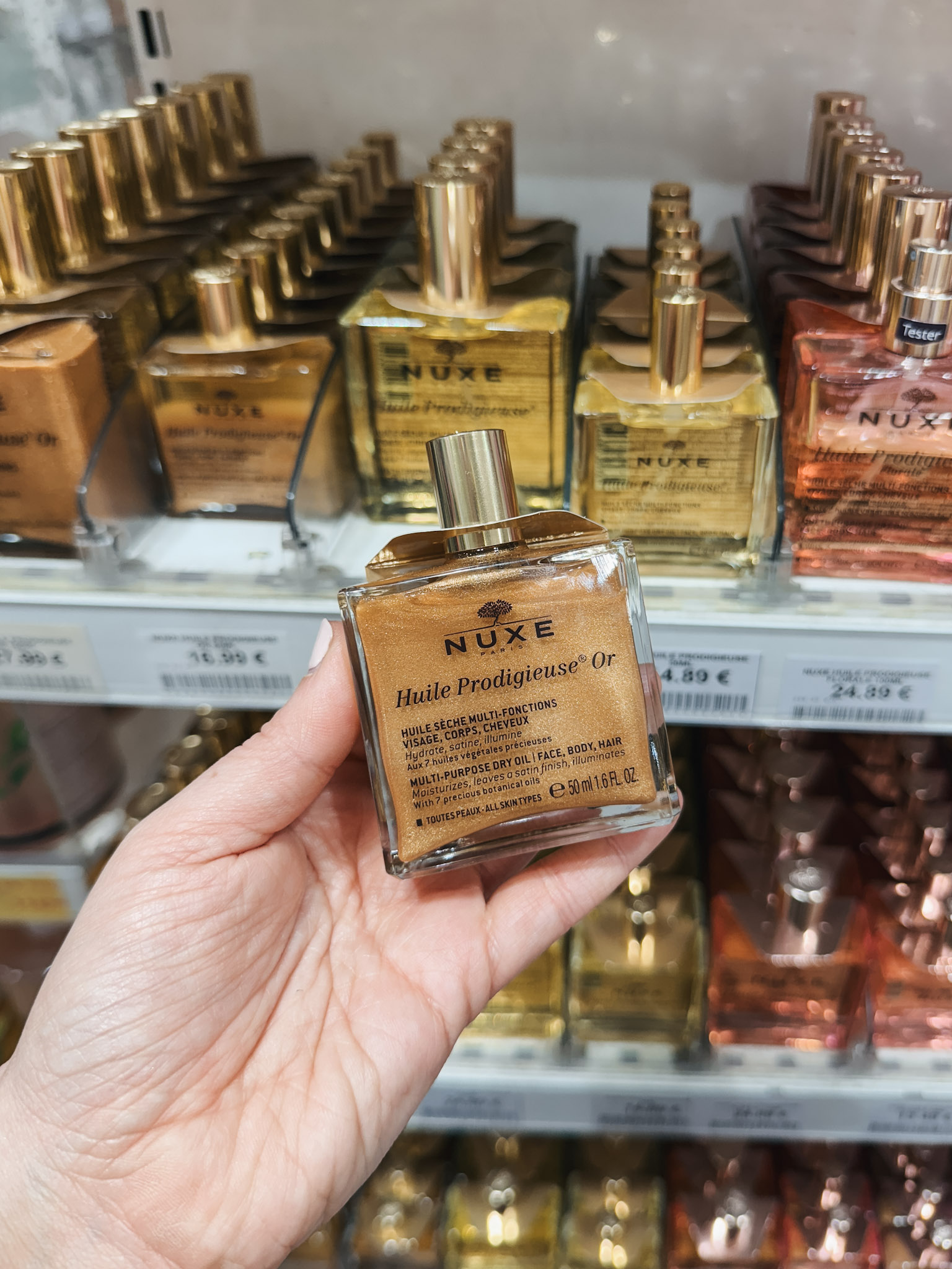 What Brands to Buy at the French Pharmacy - in photo: person holding a product from NUXE What Brands to Buy at the French Pharmacy - in photo: person holding a product from NUXE